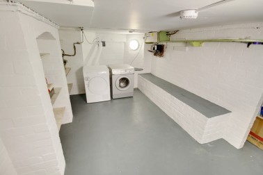 Separate laundry room in basement with washer, dryer & large upright freezer