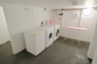 Separate laundry room in basement with washer, dryer, fridge & freezer